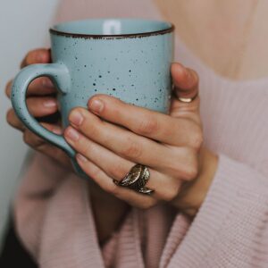 Tasse Kaffee von Händen gehalten